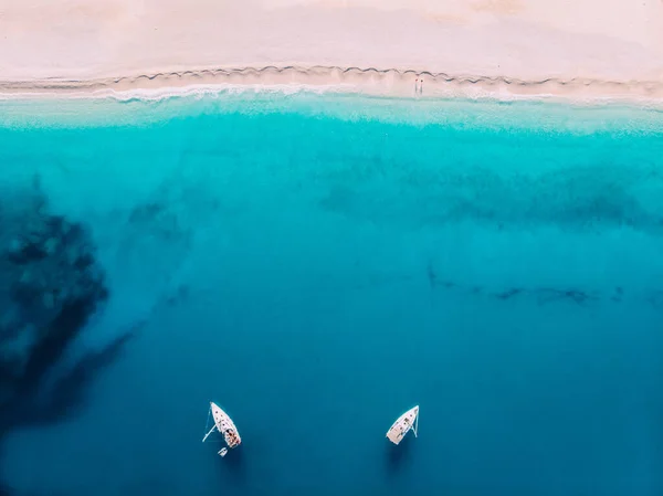 Vista aérea de arriba hacia abajo dos yates de pie en el mar cerca de la playa de arena blanca — Foto de Stock