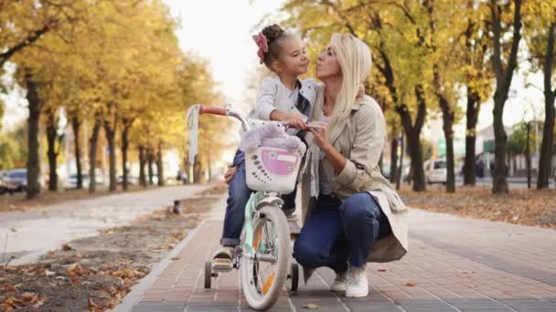 Niña abraza y besa a su madre mientras camina en el parque — Vídeos de Stock