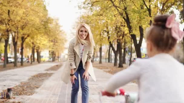 Young mother explains to her little daughter how to ride bicycle — Stock Video