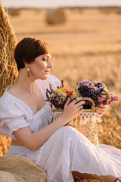 Beautiful woman on a mown field. — Stock Photo, Image