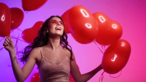 Mujer alegre con bolas en forma de corazón bailando. — Vídeos de Stock