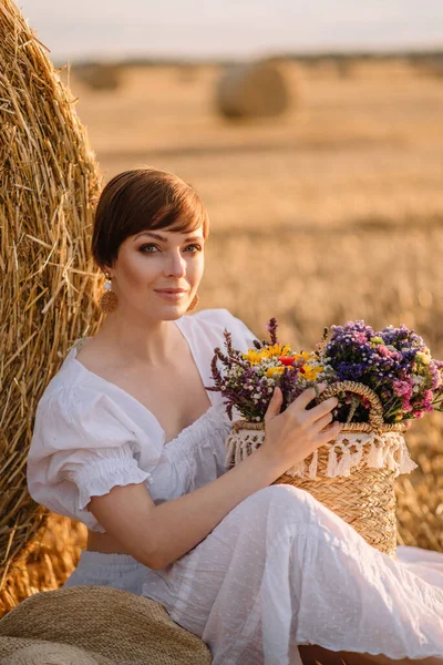 Beautiful woman on a mown field. — Stock Photo, Image