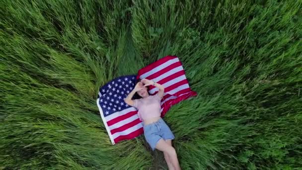 Lycklig flicka ligger på USA flaggan. — Stockvideo