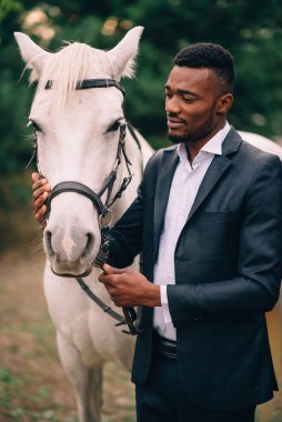 Genç bir Afrikalı at okşuyor..