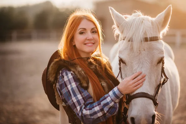 A woman stroking a horse at a ranch. — Stock Photo, Image
