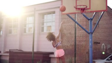 Basketbol oynayan genç bir kadın.