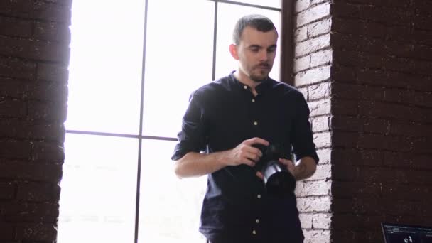 Un joven fotógrafo masculino está fotografiando a una modelo en el estudio. — Vídeos de Stock