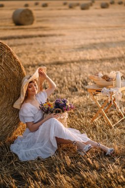 Güzel bir kadın biçilmiş tarlada.
