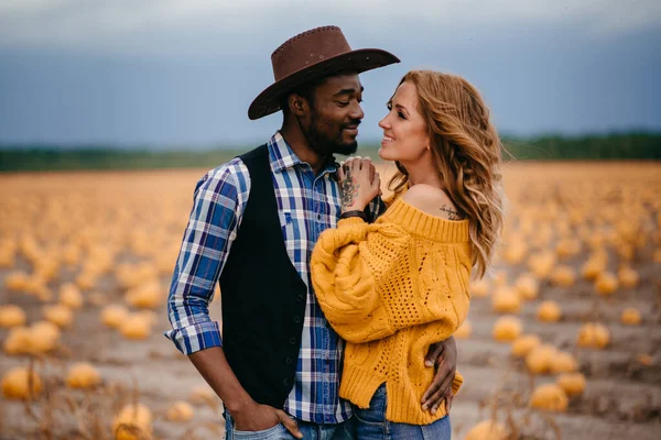 Ett par älskare står i ett pumpafält. — Stockfoto