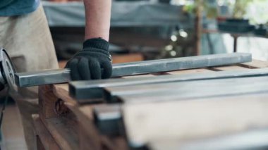 Kaynaklanmış eklemlerin öğütülmesi. Bir adam, metal bir ürünü, bir açı öğütücüyle işliyor. Yakın plan..