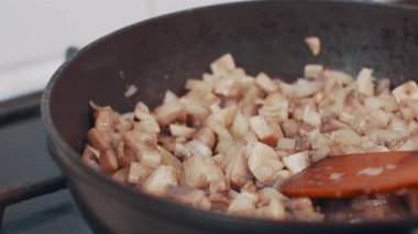 Doğranmış mantar ve soğan tavada kızartılır, yakın plan..