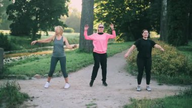 Parkta spor yapan üç orta yaşlı kız arkadaş. Ön görünüm.