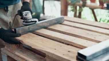 Bir işçi, çelik bir parçanın pasını öğütücüyle öğütüyor. Yakın plan..