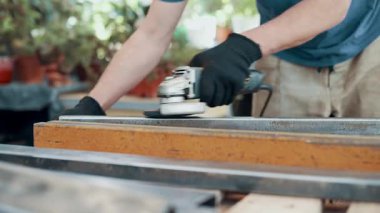 Bir işçi, çelik bir parçanın pasını öğütücüyle öğütüyor. Yakın plan..