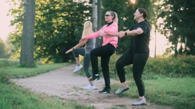 Parkta spor yapan üç orta yaşlı kız arkadaş. Ön görünüm.