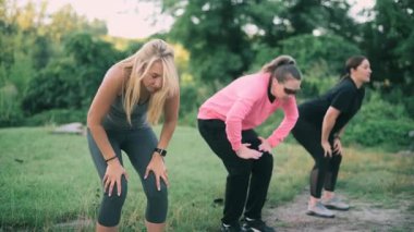 Parkta spor yapan üç orta yaşlı kız arkadaş. Ön görünüm.