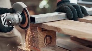 Kaynaklanmış eklemlerin öğütülmesi. Bir adam, metal bir ürünü, bir açı öğütücüyle işliyor. Yakın plan..