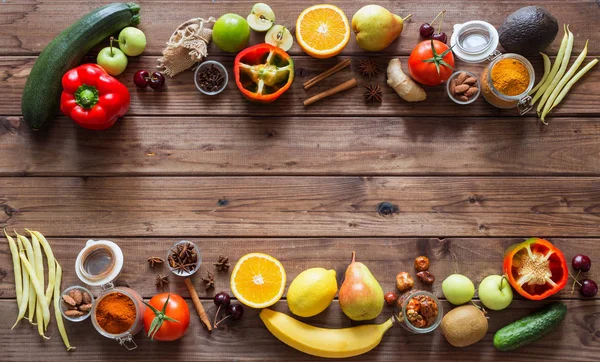Healthy food, clean food selection:  fruits, vegetables, seeds, spices on brown boards with free space in the middle