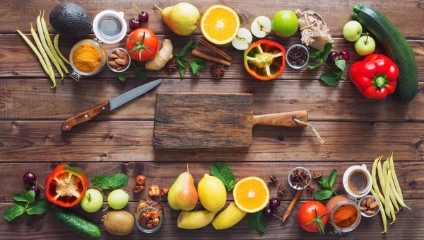 Healthy food, clean food selection:  fruits, vegetables, seeds, spices on brown boards with free space in the middle