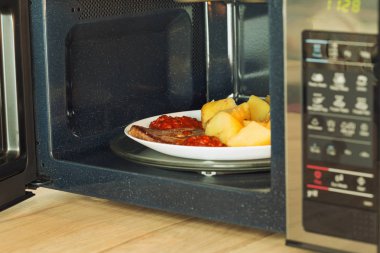 Microwave oven with a heated meal clipart