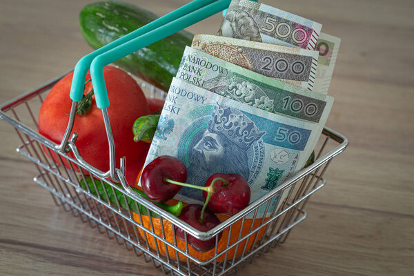 vegetables and fruits in the shopping basket along with Polish money / the concept of food price increase