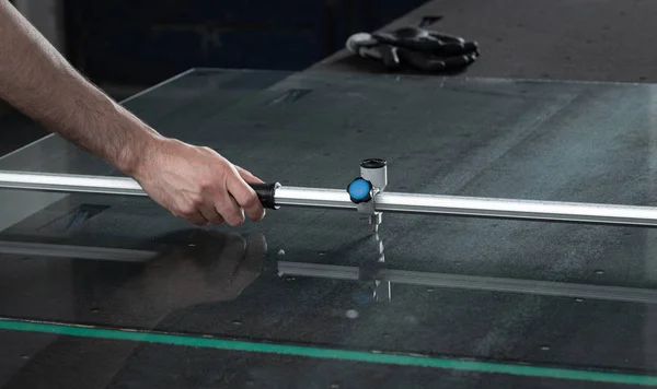 A worker cuts glass in a glass workshop