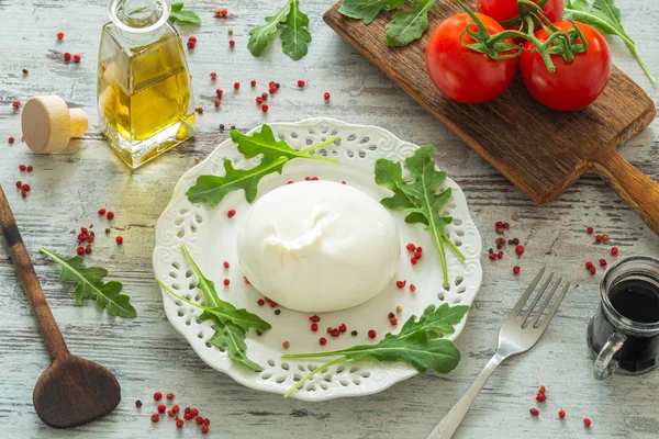 Burrata, Italian cheese with tomatoes, spices, argugula and olive oil and balsamic vinegar