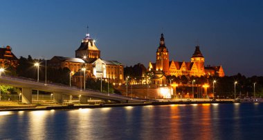 Szczecin. Nehrin karşısından ışıklı tarihi merkeze gece manzarası.