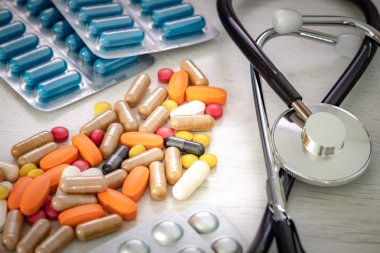 Doktorun masasında steteskop olan büyük miktarda ilaç. Kavram