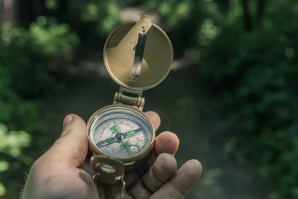 Man with a compass in his hand on the trail