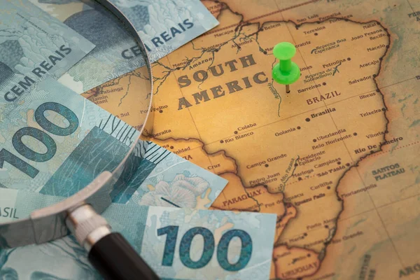 Brezilya parası, büyüteçle 100 reais, Güney Amerika haritasında yeşil noktalı, Brezilya