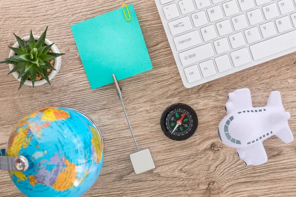 Desk with aviation and travel items. Globe, toy plane, Luggage tag, Computer keyboard, Air travel planning concept, Place for text
