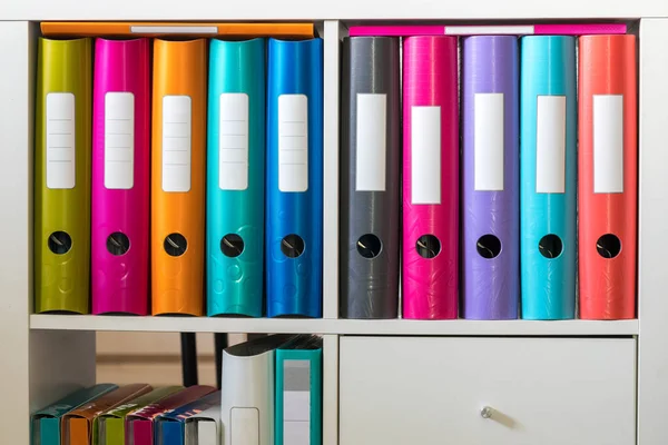 A cabinet with colorful folders and folders for office documents