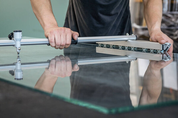 Глазурь режет стекло с помощью специализированного оборудования в профессиональной мастерской