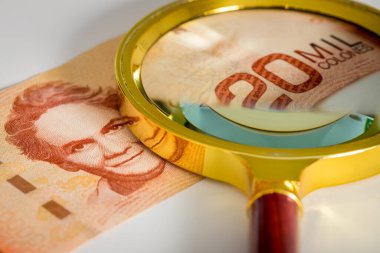 Kosta Rika parası. Üzerinde büyüteç bulunan yirmi bin Colone banknotu. Ekonomik ve bütçe durumuna bakma kavramı