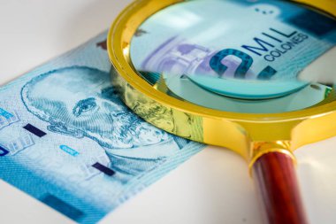 Kosta Rika parası. Üzerinde büyüteç olan iki bin Colone banknotu. Ülkenin ekonomik durumuna ve sakinlerine bakma kavramı