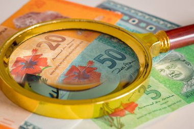 Malezya parası. Ringgit, üzerinde büyüteç olan kağıt banknotlar. Farklı değerler. İş ve bütçe kavramı