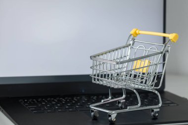 Laptop klavyesinde alışveriş arabası. Metin için alanı olan beyaz monitör ekranı. Çevrimiçi alışveriş ve online mağazalar kavramı