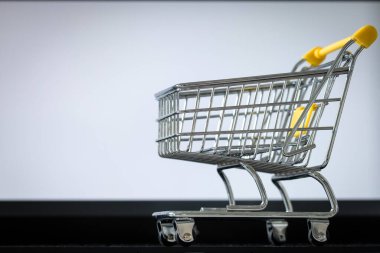 Laptop klavyesinde alışveriş arabası. Metin için alanı olan beyaz monitör ekranı. Çevrimiçi alışveriş ve online mağazalar kavramı