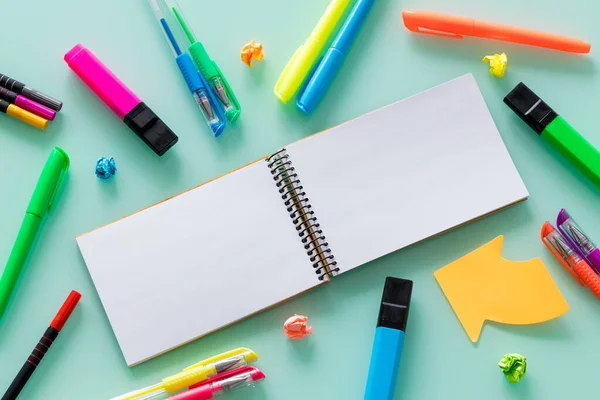 school and office items, colored pens, staples, felt-tip pens, set squares, a blank notebook for your own text in the center.