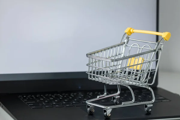 笔记本电脑键盘上的购物车 白色显示屏 带有文字空间 网上购物和网上商店的概念 — 图库照片