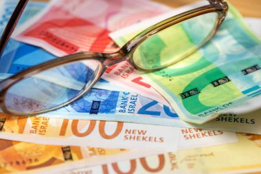 İsrail parası. Eski moda bardaklar İsrail şekellerinin üzerinde duruyordu. Finansal ve iş konsepti. Kapat.