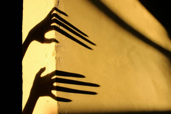 Strange Shadows On The Wall.Terrible Shadows. Abstract Background. Black Shadows Of A Big Hands On The Wall. Silhouette Of A Hands On The Wall. Nightmares. Scary Dreams.