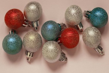 Metin için yer bir sürü pembe bir arka plan üzerinde renkli Noel dekorasyon topu. Noel, yeni yıl, tatil, arka planlar kavramı. Noel oyuncaklar.