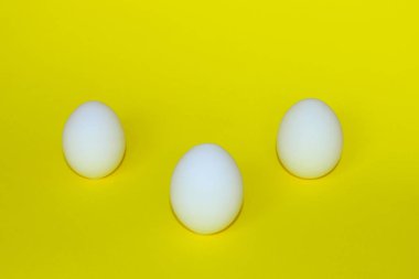 Sarı arka plan üzerinde beyaz yumurta. Renkli gıda arka plan. Minimalizm, gıda, Paskalya kavramı. Arka plan. Minimal sanat tasarım.