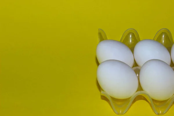 黄色の背景の上の白い卵 カラフルな食品の背景 ミニマリズム イースターのコンセプト 抽象的な背景 ミニマルなアート デザイン — ストック写真