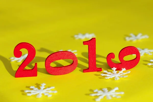 Christmas, Holidays, New Year Concept. Red Figures 2019 And White Snowflakes  Over Yellow Background. Colorful Background For New Year Card.