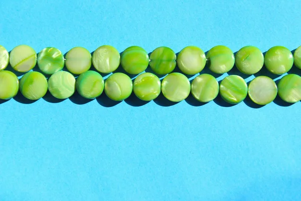 Green Beads Over Blue Background. Abstract Colorful Background Texture. Green And Blue Colors.