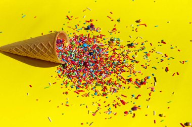 Renkli arka plan. Çok renkli şeker tatlı sarı zemin üzerine. Çok renkli küçük şeker closeup. Şeker dondurma Cone.Minimal sanat tasarım.