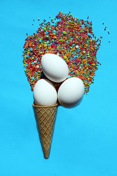 休日の概念 つの白い卵と青い背景上のワッフル コーン アイスクリームの記号 — ストック写真